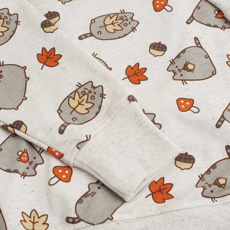 close up of pusheen sweatshirt with fall leaves and pusheen holding acorns and mushrooms