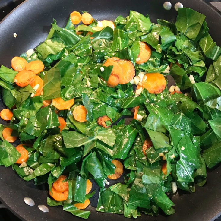 carrots, garlic, and collard greens cooking in pan