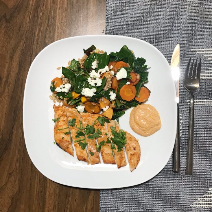 Completed Harissa-Baked Chicken with Farro, Persimmon, and goat cheese salad on a plate