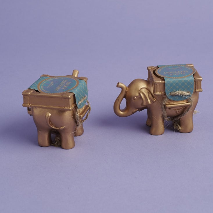 the front and back of a pair of elephant votive candle holders