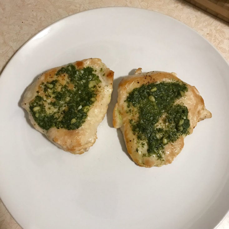 cooked chicken breasts with basil pesto on plate