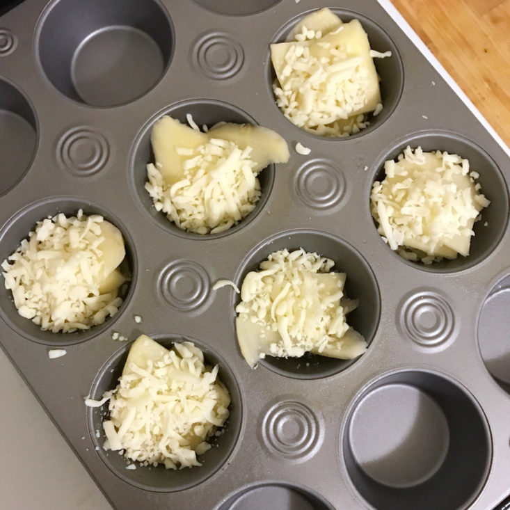 sliced potatoes in muffin tin with cheese