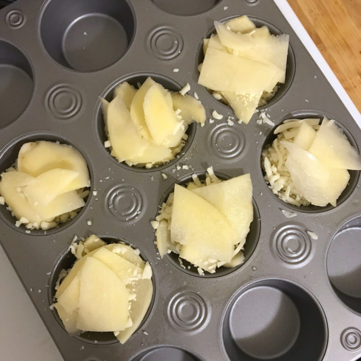 second layer of sliced potatoes covering cheese in muffin pan