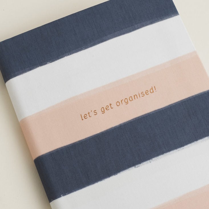 close up of rose gold foil "let's get organised" quote on Peach and Blue Striped Linen Notebook