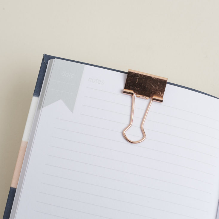 rose gold binder clip on notebook page