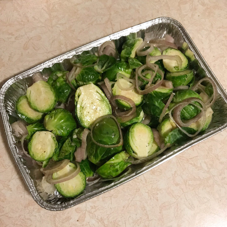 halved raw brussels sprouts with sliced shallots in tin
