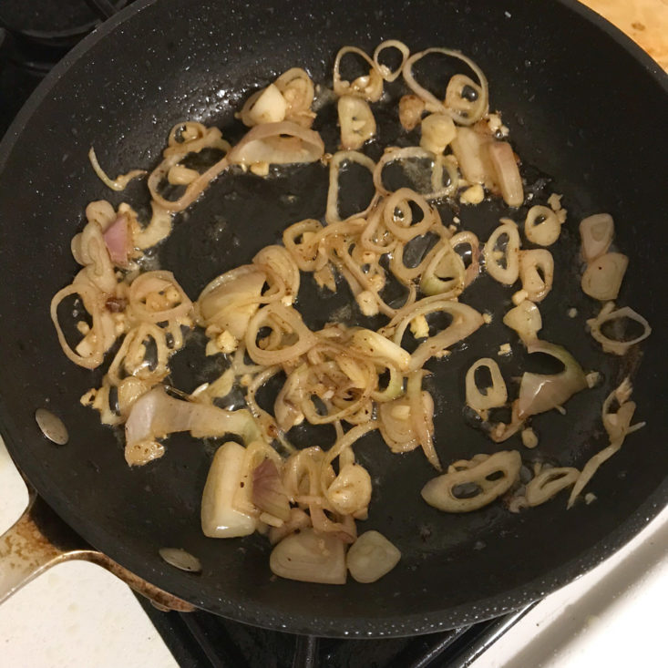sliced shallots and garlic sauteing in pan