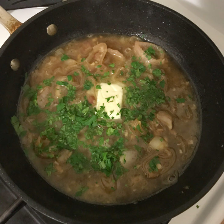 sliced shallots and garlic in pan with apple cider, chicken stock, butter, and parsley