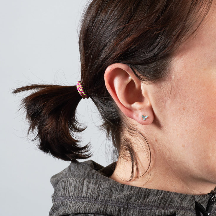 tiny blue butterfly earrings on a person