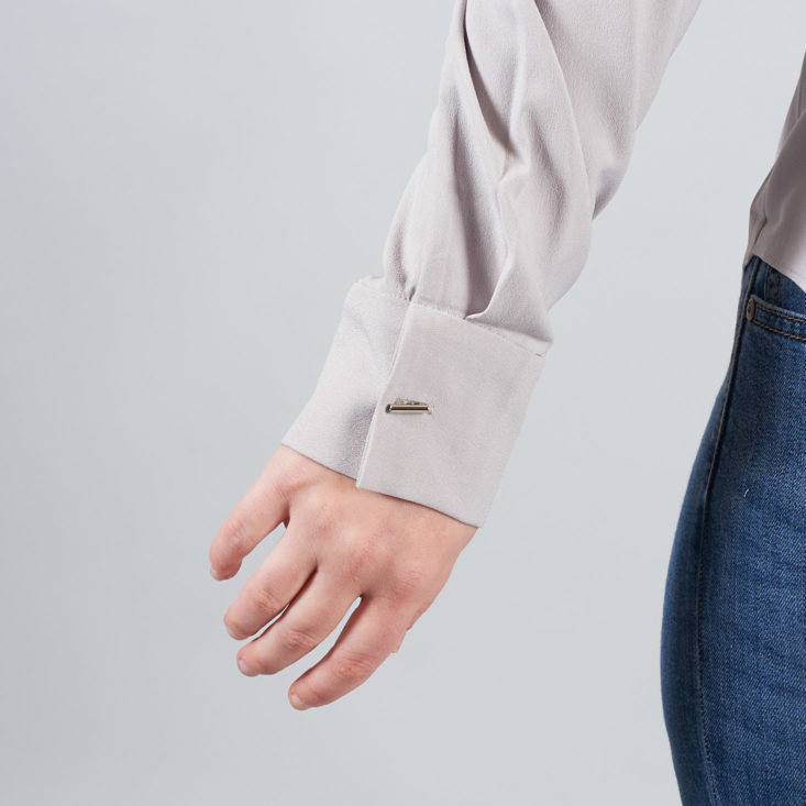 bar button on cuff of gray shirt