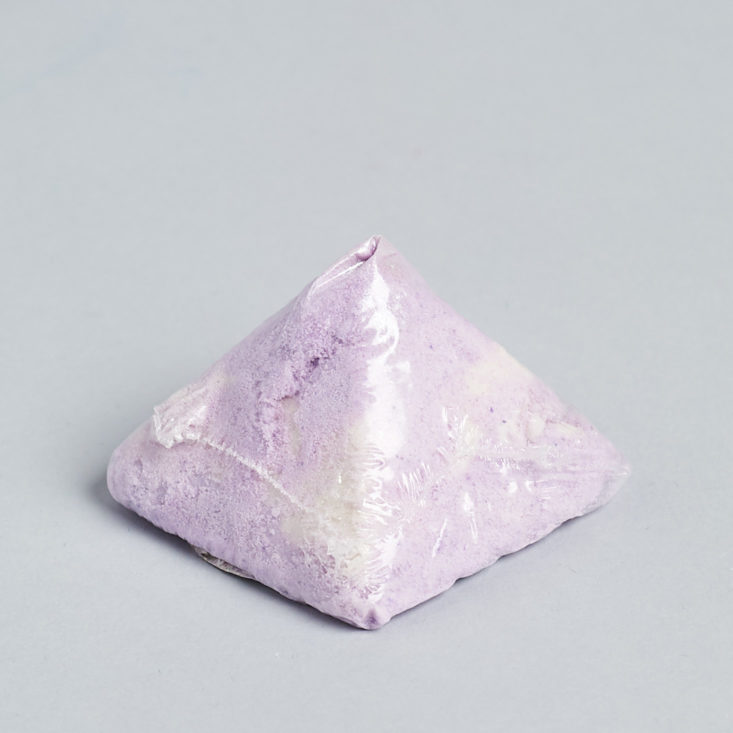 purple pyramid shaped bath bomb wrapped in plastic