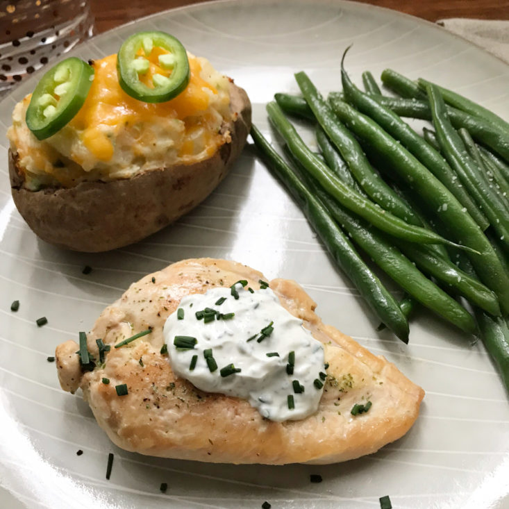 close up of plated ranch chicken with jalapeno popper twice baked potato