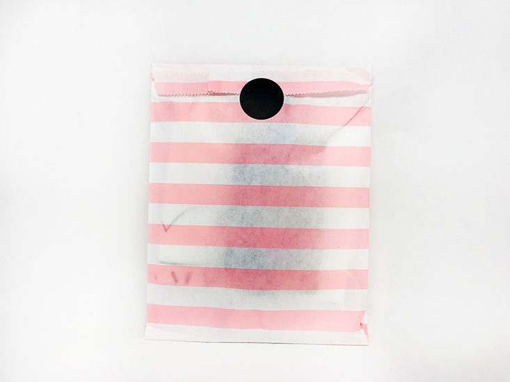 white and pink striped paper bag closed