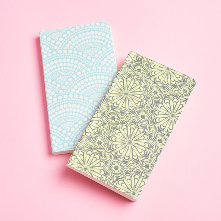 Two slim notebooks with lots of circular patterns.