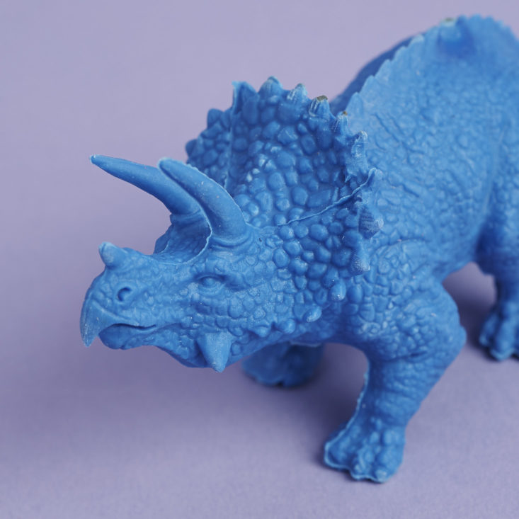the head of a bright blue oversized eraser shaped like a triceratops