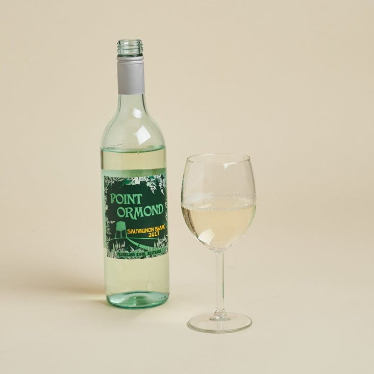 white wine poured in a glass with a bottle next to it