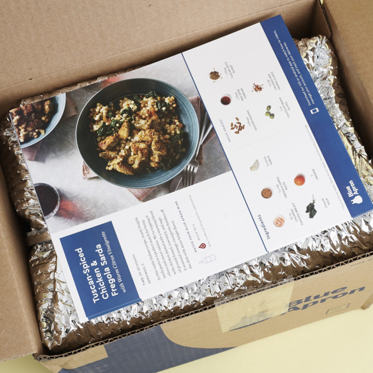 looking inside a Blue Apron Box with recipes on top