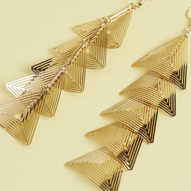 close up of Gold dangly triangle earrings