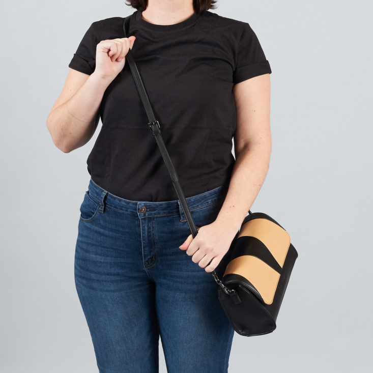 woman wearing tan and black shoulder strap bag