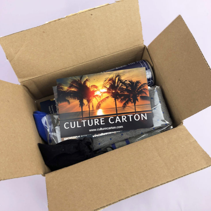 open Culture Carton box showing a postcard with palm trees and orange sunset