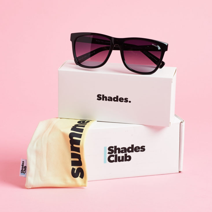Black sunglasses on top of Shades Club box with dust pouch